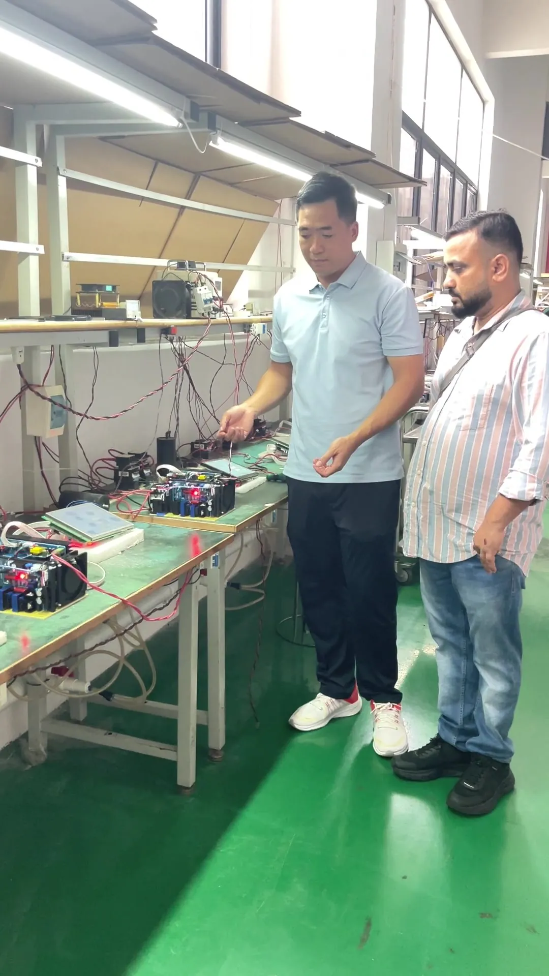FQBeauty representative showing machine electronics to an overseas buyer during a factory inspection